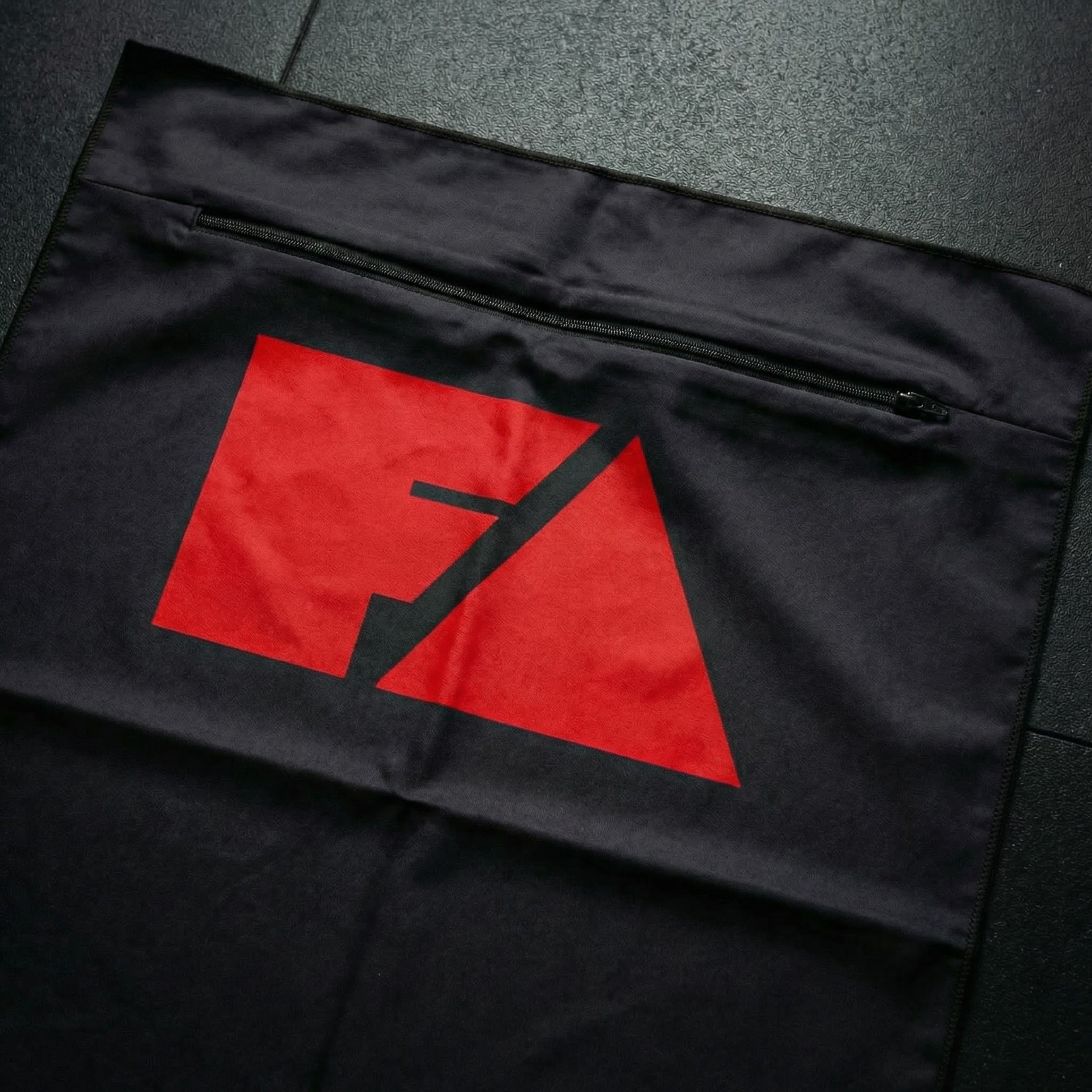 Black bag with a red logo on a dark textured surface