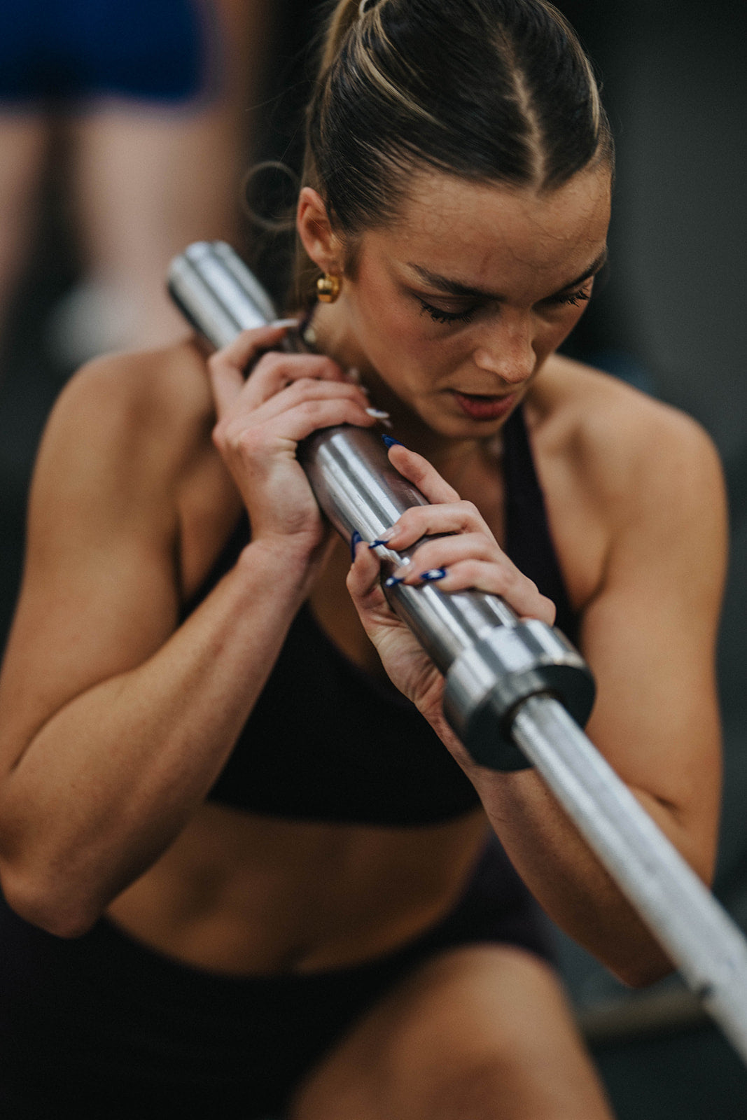 Woman lifting weights in gym wearing performance activewear